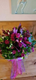 Hand Tied Bouquet in an Aqua Pack Predominantly Fuchsia Pinks and Purples   Florist's Choice